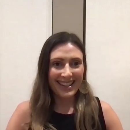 Angela Russo-Otstot is smiling as she is attending a video call.